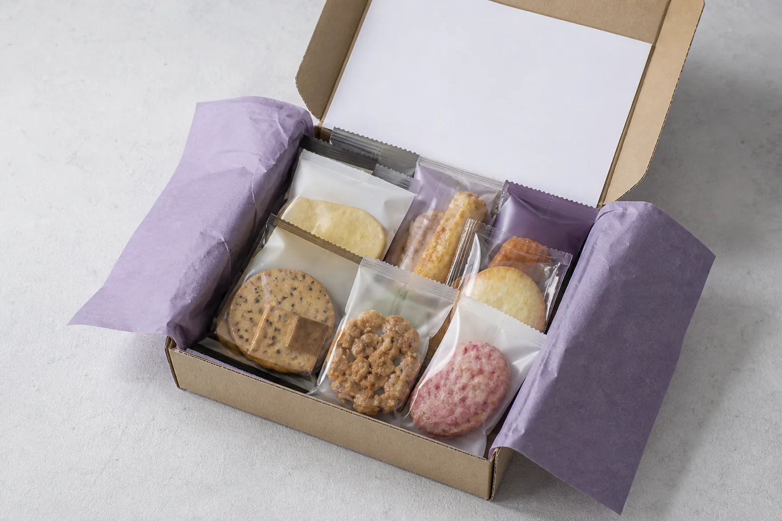An open unbranded delivery box filled with individually sealed snacks